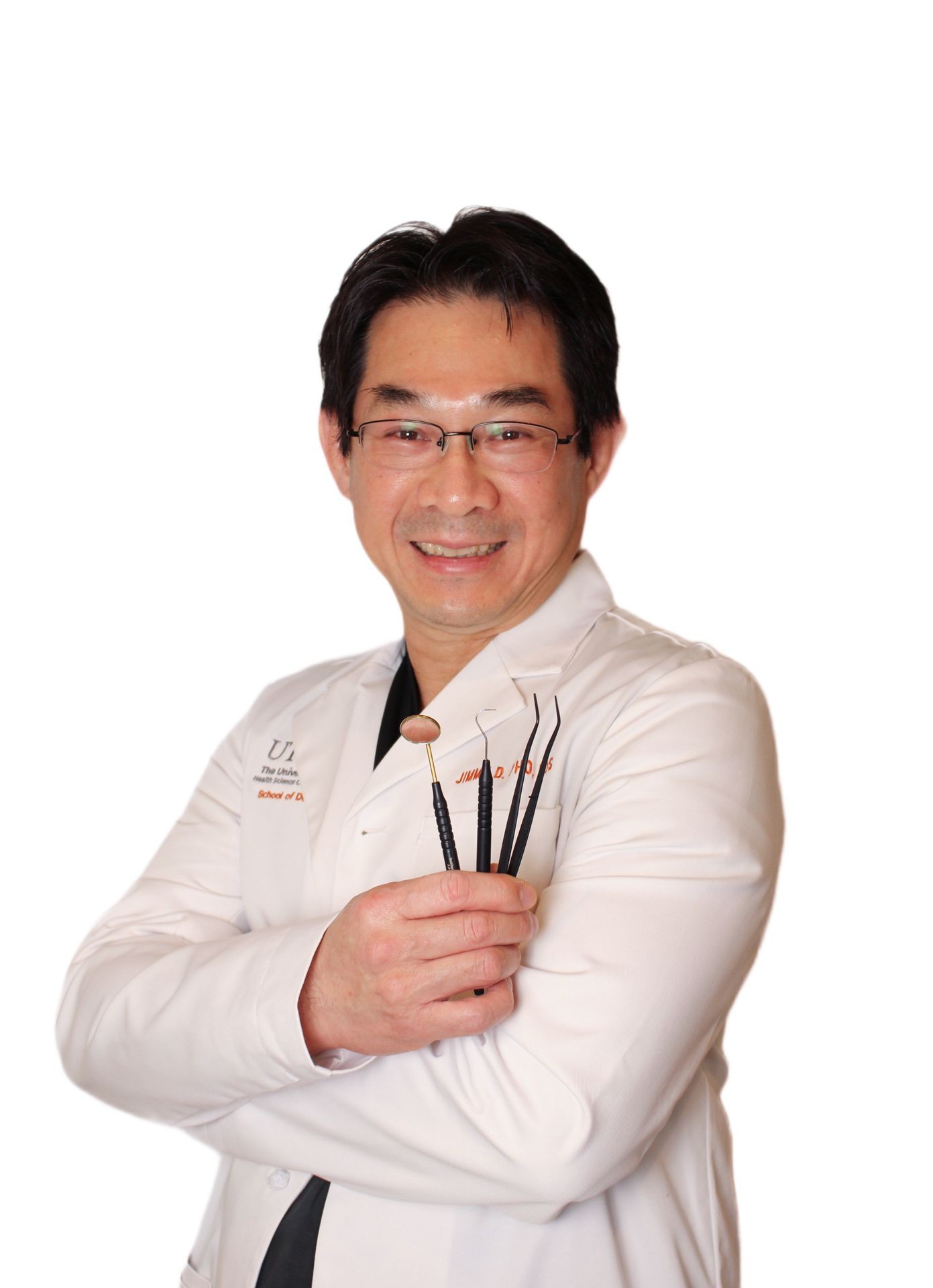 Person wearing a white lab coat holding dental instruments in their hand.