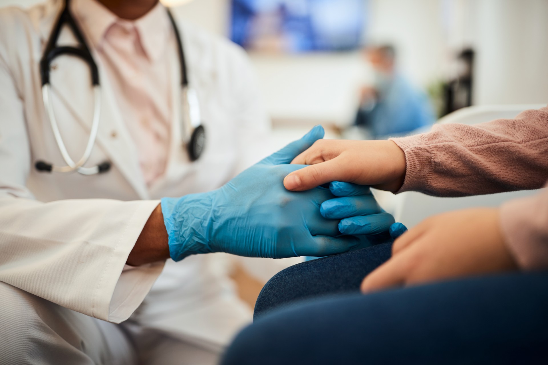 Close up of little girl holding her dentist's hands in waiting room at dental clinic.